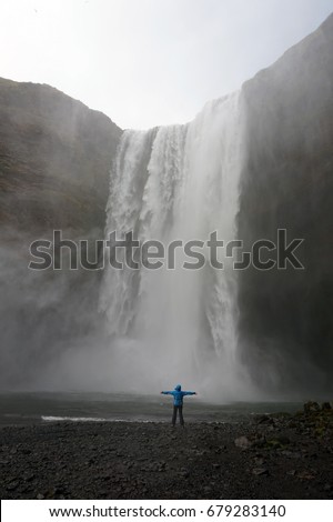 One woman is staying at the front of Skogafoss waterfall, South of Iceland