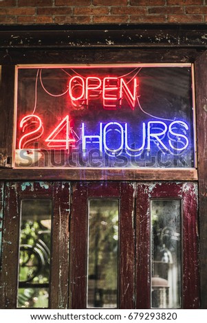 This shop is open 24 hours. Made of red and blue neon tubes. Set on a wood door retro.