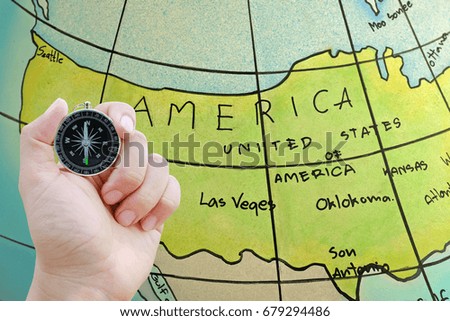 Compass in hand against globe map background