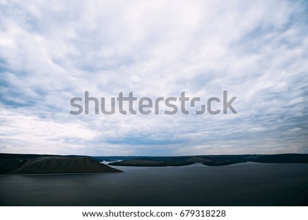View of a bay and distant coastline with dark clouds before a rain