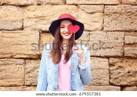 Beautiful young woman with bright lips on brick wall background