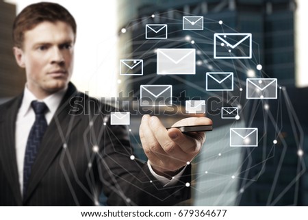 Handsome european businessman holding smartphone with email network on blurry background