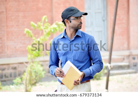 happy stylish indian young man reading book outdoor