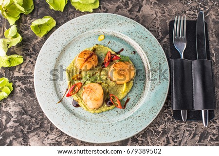 Seafood snack -  Sea scallops and vegetables, glass of wine and flowers. Close-up on a black table. Healthy fresh food.