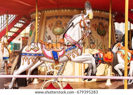 Horses on a carnival Merry Go Round. Old French carousel in a holiday park. Big roundabout at fair in amusement park.