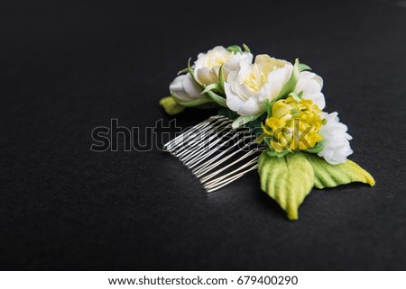 Wedding hair pin decorated with artificial flowers on black background