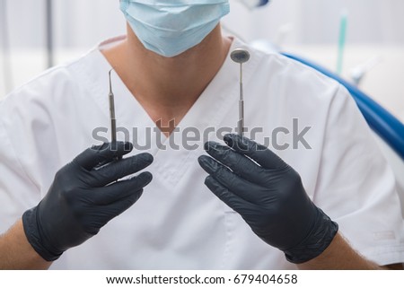 Portrait of happy male dentist wearing lab coat while sitting in clinic.A portrait of a dentist