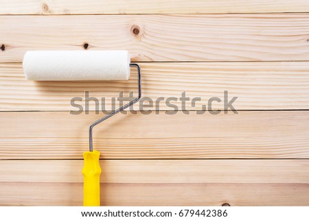 paint roller on wooden background