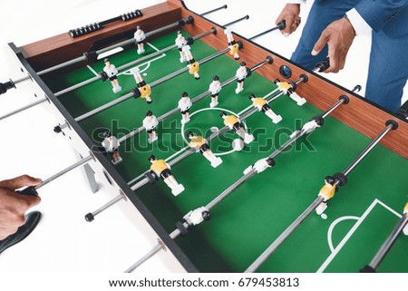 cropped shot of businessmen playing table football isolated on white