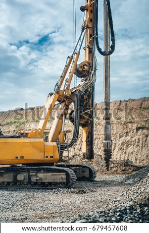 Industrial drilling rig machinery on highway construction site. Viaduct construction and bridge pillar details Royalty-Free Stock Photo #679457608