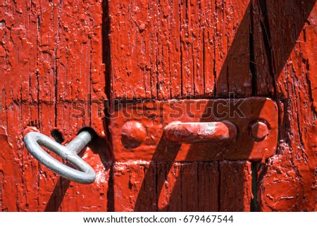 Antique iron key from the gate in the old red wooden gate.