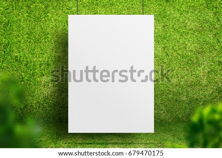 Blank white poster hanging at green grass room with blur leaf foreground,Ecology sustainable concept,Mock up for display of design