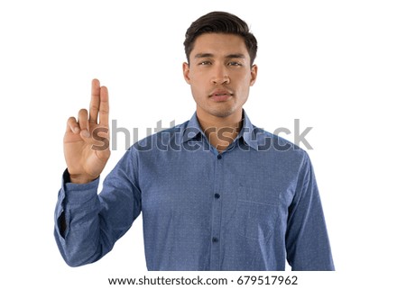 Portrait of businessman gesturing while standing against white background