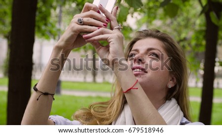 Close up portrait of young woman taking pictures on the smartphone