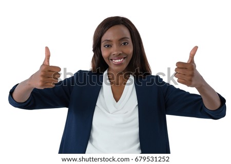 Portrait of happy businesswoman showing thumbs up against white background