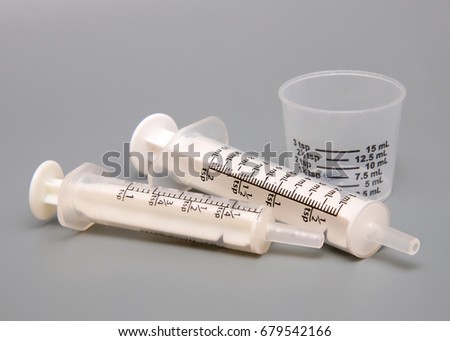 Oral medicine syringes and dosing cup Royalty-Free Stock Photo #679542166