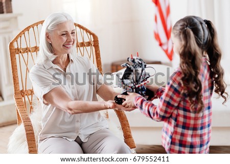 Profile photo of positive girl that standing opposite her grandma