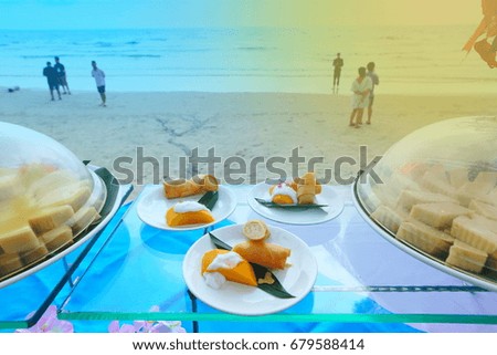 Buffet Dessert of spring roll and mango in three dishes along beautiful beach with blur people, spring summer vacation holiday