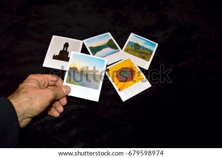 Hand choosing a photo among six options over a black background