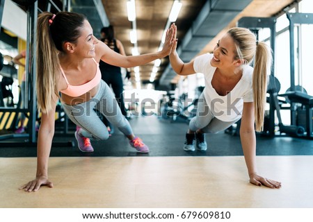 Two attractive fitness girls doing push ups Royalty-Free Stock Photo #679609810