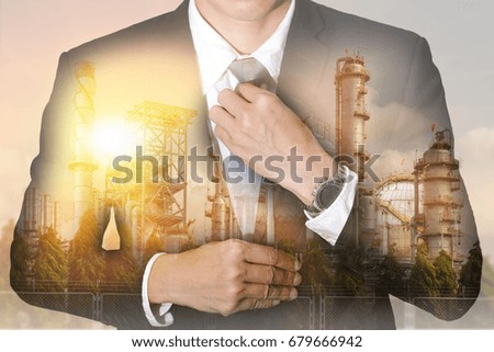 Double exposure of businessman held necktie dress to look good, oil fuel, Electric generating factory, plant and sunset  as business, industrial and energy concept.