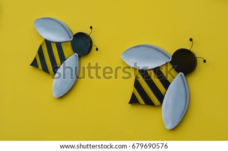 Statue of a bee wall mounted on a yellow background, Blank space for text input.