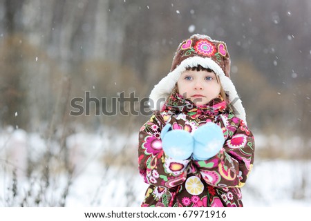 Stock Photo: Winter portrait of small girl in colorful snowsiut and warm hat