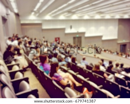 blurred image of Business Conference and Presentation. People Meeting Conference Seminar, Audience at the conference hall. - interior of a conference hall, warm & vintage tone photo.