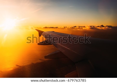 Warm picture of airplane wing before landing on the coast