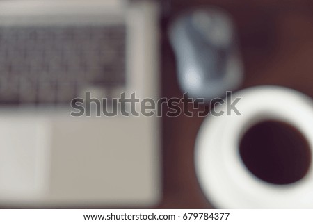 Blur image of Laptop and black coffee in the morning time with bokeh for background usage.
