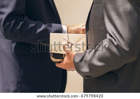 Business man giving a gift with envelope and shaking hands