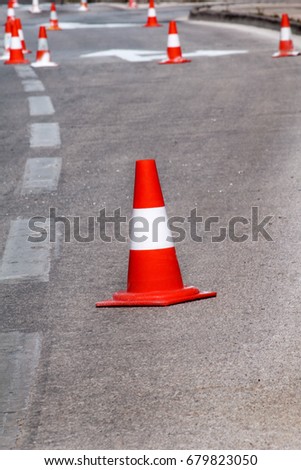 Work on the road. Street signs and road marking. Traffic signs for signaling. Road maintenance, under construction sign and traffic cones. Road block with white arrow showing alternate way.