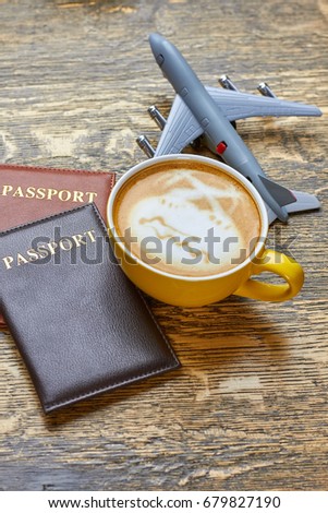 Coffee, passports and toy plane. Documents on wooden background. Taste of vacation.