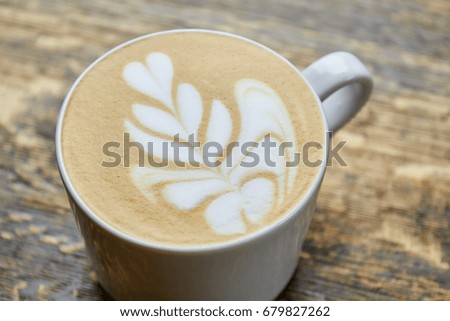 Flower latte foam art. Coffee cup close up.