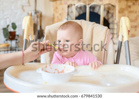 A cheerful happy child eats porridge.