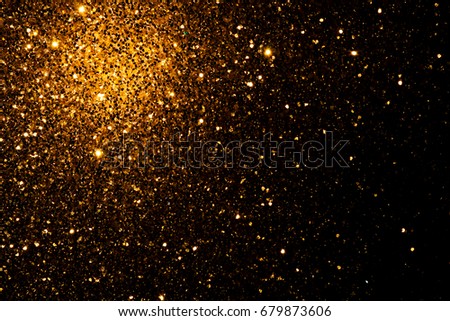 Abstract and festive background with golden yellow lights. De focused blurred lights.