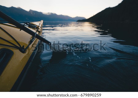 Paddle of kayaker in water while sunset