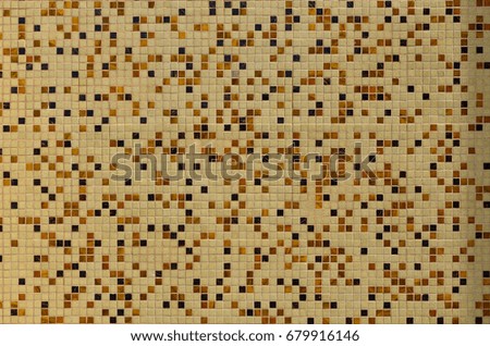 The texture of the wall, decorated with a mosaic of various small square tiles. Abstract pattern of ceramic tiles on the wall