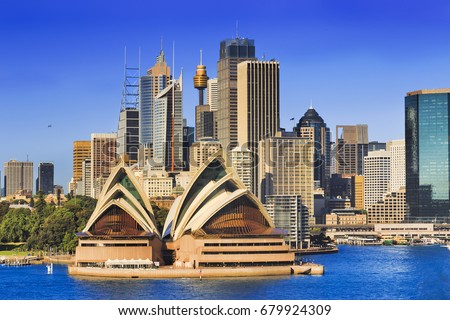 Sydney city landmarks and high-rise towers across harbour on a bright sunny day - modern architecture of office and business buildings.