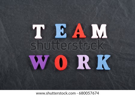 TEAM WORK word on black board background composed from colorful abc alphabet block wooden letters, copy space for ad text. Learning english concept