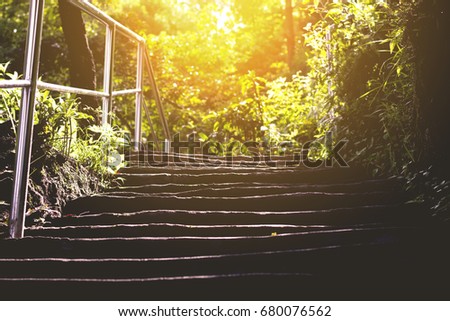 low key background of staircase with light at the top, concept of way to success is not so easy