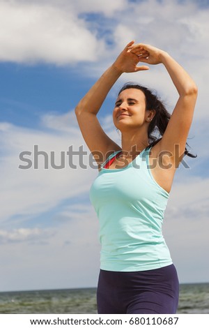 attractive young girl practicing physical exercises on a beach in the summer