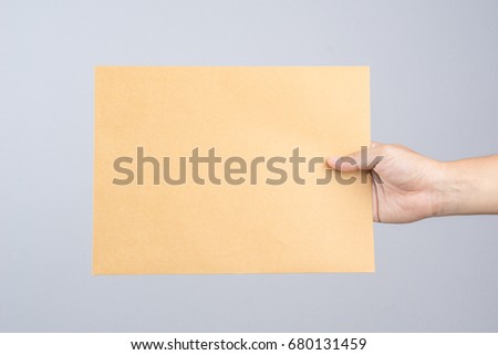 Hand holding a self sealing brown envelope document on white background