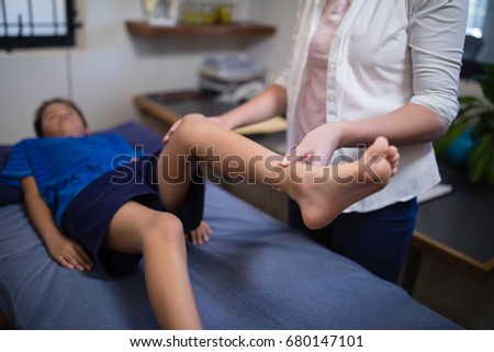 High angle view of female patient examining boy lying on bed at hospital ward