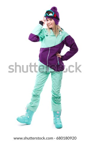 vertical picture, isolated on white, pretty caucasian woman in purple ski outfit, blue trousers and snow glasses, bend, hand on glasses