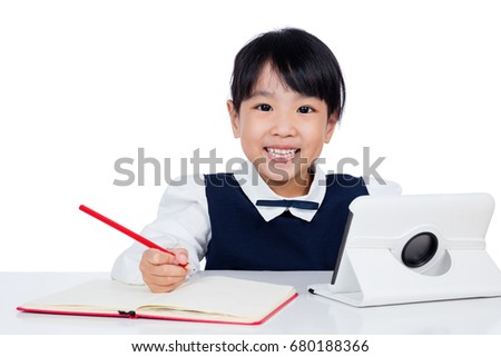 Asian Chinese little girl in uniform studying with tablet computer in isolated white background