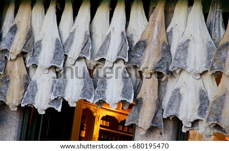 Salted cod hanging outside a shop in Porto, Portugal. Royalty-Free Stock Photo #680195470