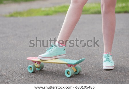 teen girl down the street with a skateboard