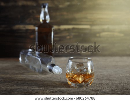 Bottles and glass of alcohol on wooden floor