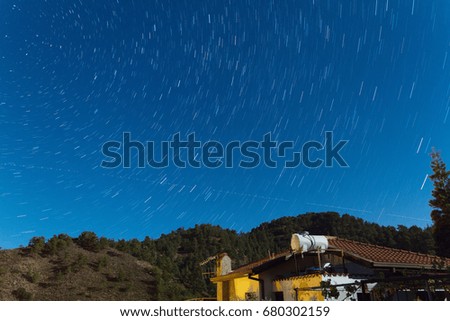 Time Lapse Star Trails over a house at the Troodos mountains as an aeroplane traverses the sky. Captured over Kakopetria village in Cyprus